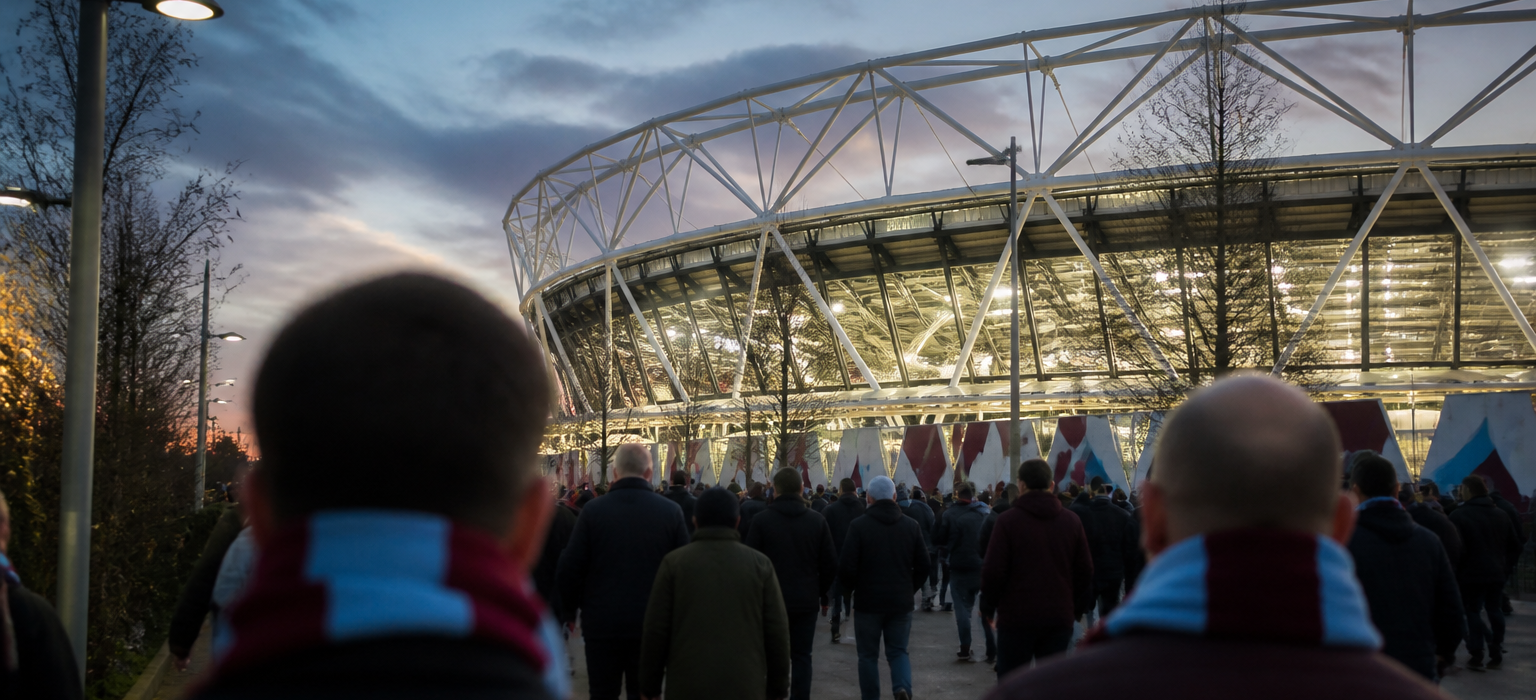 West Ham fans in claret and blue walking toward London Stadium at dusk