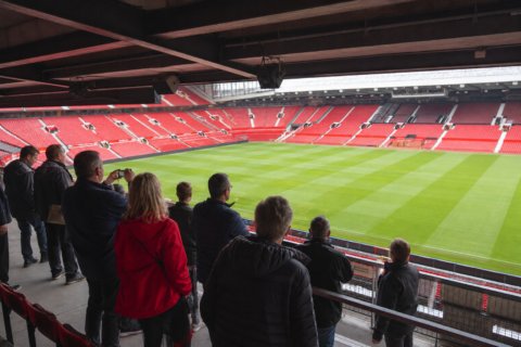 Visitors on an Old Trafford stadium tour looking out over the pitch