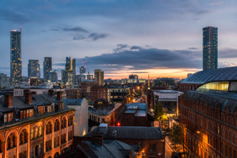 Manchester city skyline with football fans arriving at Piccadilly station